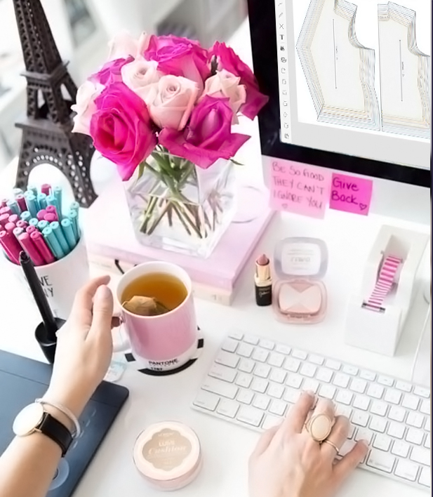 foto mostrando mulher usando o sistema da molde.me, uma mesa com vários objetos rosas como flores, batom e canetas