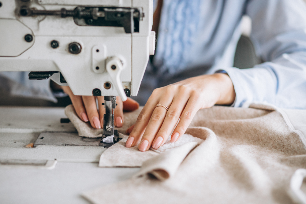 Mulher costurando peça em máquina de costura industrial