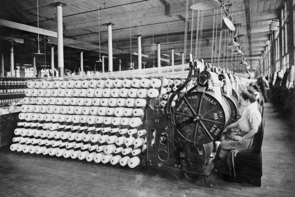 Mulher trabalhando em confecção têxtil durante período de revolução industrial